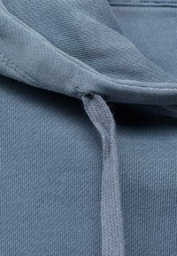 Teren de hanorac albastru cu un design texturat din tricot, având un șnur și un guler ușor ridicat. Vedere aproximativă care evidențiază detalii ale materialului.