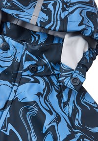Waterproof jacket featuring a blue and black marbled pattern, with a smooth texture, snap buttons, and reflective detailing on the collar.