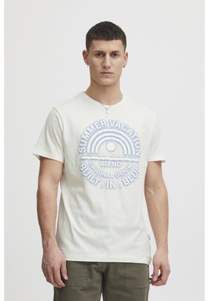 Light beige cotton t-shirt with a multicolored circular graphic text design reading “SUMMER VACATION” and “BUILT IN BLUE.” Short sleeves.