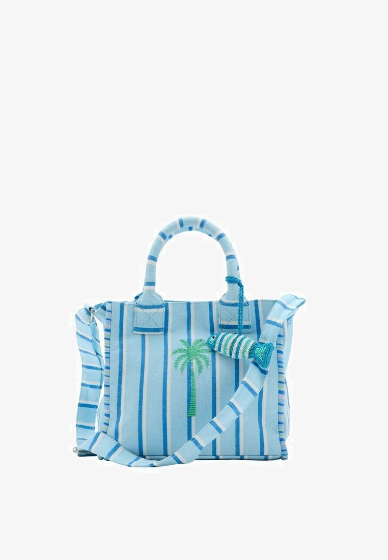 Sac fourre-tout rayé bleu clair et blanc avec une broderie de palmier et un porte-bonheur en forme de poisson en perles suspendu à une poignée.