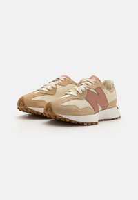 Beige semsket og skinn sneakers med rosa aksent, som har en teksturert overflate, rund tå og en gummisåle med sirkulære grep.