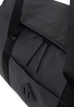 Sac de sport noir avec une texture lisse, doté de doubles fermetures éclair et d'un design en tissu durable. Comprend un accent avec logo et des sangles plates.