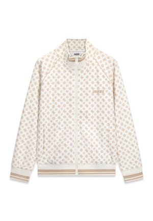 Veste blanche zippée avec un motif logo beige répété, des poignets et un bas côtelés avec des rayures beiges, et le texte "GUESS" sur la poitrine gauche.