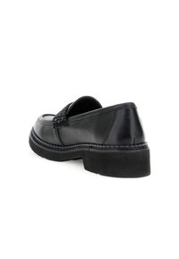 Scarpa nera in pelle slip-on con dettagli a banda testurizzati, tacco basso a blocco e cuciture intricate lungo la suola, che mostrano una finitura liscia.