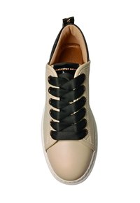 Sneaker met een gladde beige leren bovenkant, zwarte gevlochten veters en een slanke witte rubberen zool. Interieur gevoerd met lichtbruin leer voor comfort.