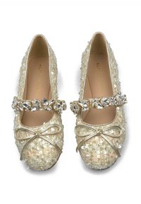 Bailarinas beige con lentejuelas, puntera redondeada, detalle de lazo metálico y una tira con joyas. Parte superior de textil suave y interior acolchado.