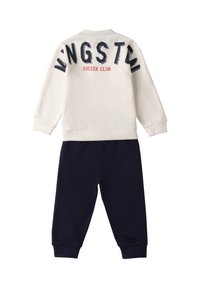 Conjunto de dos piezas que incluye un sudadera color crema con el texto "KINGSTON SOCCER CLUB" en azul marino y rojo, acompañada de pantalones de chándal en color azul marino.