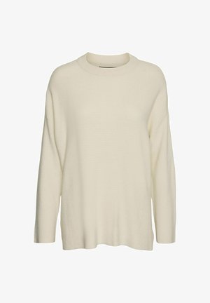 Kreemikas värvi kudum, millel on kõrge kaelus, pikad varrukad ja lõtva, kastikujuline siluett. Kangas näeb välja tekstuurne ja pehme.