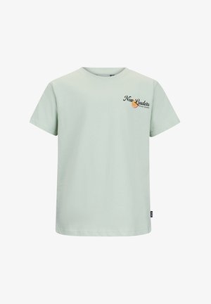 Lichtgroen T-shirt met korte mouwen en de tekst "New Leaders Retour Jeans" met een sinaasappelschijfje grafiek op de linkerborst.