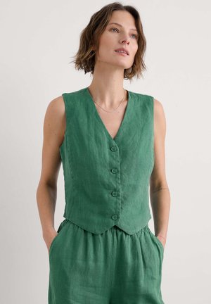 Gilet in lino verde con scollo a V, apertura con bottoni e senza maniche. Caratterizzato da un orlo scallopato e tasche laterali per una maggiore funzionalità.