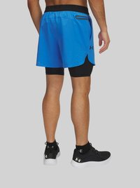 Blue athletic shorts with perforated detailing, paired with black compression shorts and sleek black athletic shoes.