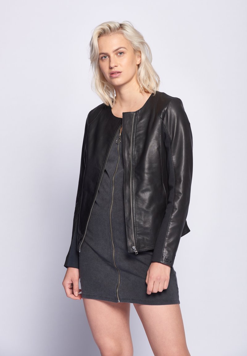 Schwarze Lederbomberjacke mit rundem Ausschnitt, Frontreißverschluss, gerippter Textur und kontrastierenden Stoffakzenten an den Ärmeln.