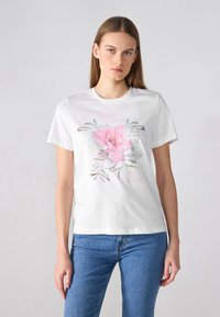 Hvit t-skjorte i bomull med et blomsterdesign i rosa og grønt, med teksten "IKKE BEKYMRE DEG, VÆR GLAD." Vanlig passform og korte ermer.