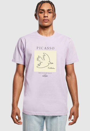 Lilac cotton t-shirt featuring Picasso's "Dove of Peace" graphic in black on a cream background, with text label beneath the design.