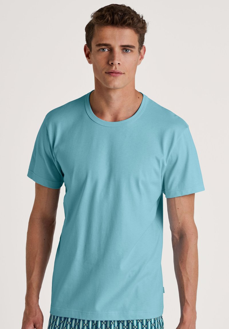 Turquoise t-shirt met korte mouwen van zacht fabric, met een ronde halslijn en een ontspannen pasvorm. Eenvoudig, effen kleur zonder patronen.