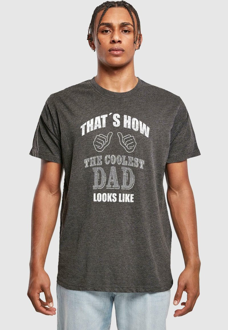 Camiseta de algodón gris con texto y gráfico en blanco que muestra un pulgar hacia arriba. El texto dice: “Así es como luce el papá más genial.” Mangas cortas, corte relajado.