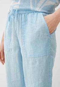 Lichtblauwe linnen broek met een elastische tailleband, voorzien van twee zijzakken en een losse pasvorm voor optimaal comfort. Gestructureerde stof met een minimale glans.