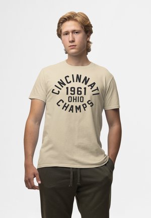 Beige bomulds t-shirt med fed sort tekst: "CINCINNATI 1961 OHIO CHAMPS." Kortærmede og med rund halsudskæring, vist fra en frontal vinkel.