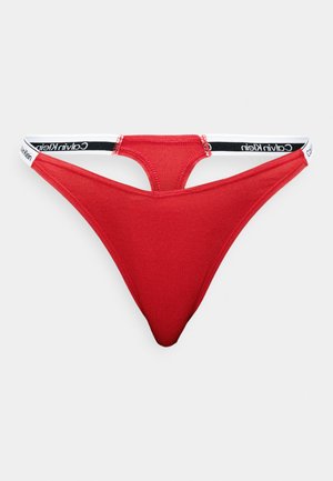 Rød bomullsstring med lav midje-design, med en svart og hvit merket midjebånd. Glatt tekstur, minimal dekning.
