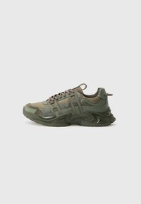 Groene sportieve sneaker van mesh en synthetische materialen, met een getextureerde zool, vetersluiting aan de voorkant, een gewatteerde schacht en merkaccenten aan de zijkant.