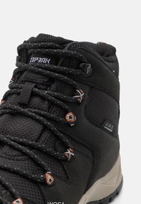 Stivale da trekking nero con tomaia texturizzata, lacci con accenti arancioni a contrasto e etichetta impermeabile. Suola in gomma con una forma che offre supporto.