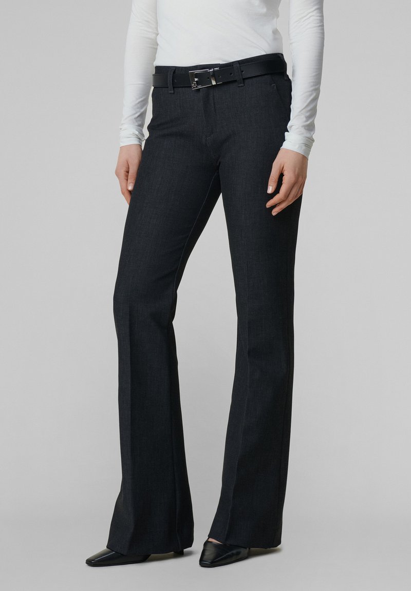 Mørk denim flared bukser med et ensfarvet design, forlommer og et sort læderbælte med sølvfarvet hardware. Glat tekstur og skræddersyet pasform.