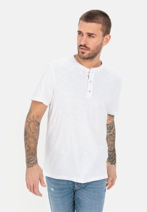 Hvid kortærmet t-shirt lavet af tekstureret stof, med rund halsudskæring, tre-knap lukning og en afslappet pasform.
