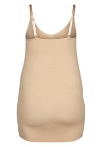 Beige formande topp med justerbara band, slät textur och sömlös design. Har graderade kompressionszoner för stöd.