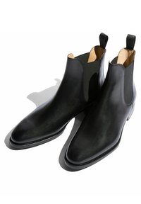 Botas Chelsea de cuero negro con paneles laterales elásticos, punta afilada y un acabado texturizado, con un interior suave y lengüetas para ayudar a ponerlas.