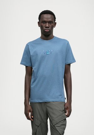 Zils kokvilnas T-krekls ar "Ripcurl" logotipu gaiši ziliem un tumši ziliem toņiem uz krūtīm. Apaļa kakla izgriezuma, īsām piedurknēm, regulāra piegriezuma.