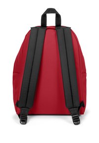 Mochila de nylon roja con correas de hombro negras acolchadas y un asa en la parte superior. Textura suave con un diseño simple y redondeado.