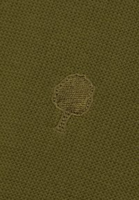 Icona di albero ricamata su tessuto a maglia texturizzato verde oliva.