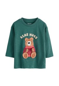 Camicia verde in cotone a maniche lunghe con una grafica di un orso e il testo "BEAR HUGS", maglione rosso e dettagli beige. Tessuto morbido e testurizzato.