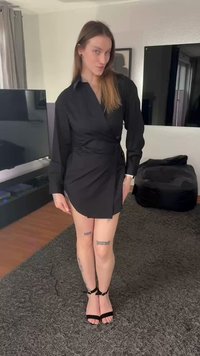 Robe portefeuille noire à manches longues, tissu texturé, décolleté en V et fente latérale, associée à des sandales à talons hauts noires à lanières.