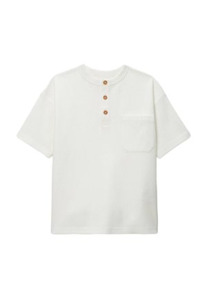 T-shirt blanc à manches courtes avec un col rond, trois boutons en bois au niveau de la patte de boutonnage et une petite poche sur la poitrine gauche. Tissu texturé.