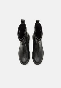 Schwarze Leder-Stiefeletten mit glatter Oberfläche, Reißverschluss und dekorativen Nieten entlang der Vorderseite. Rundliche Zehenform.