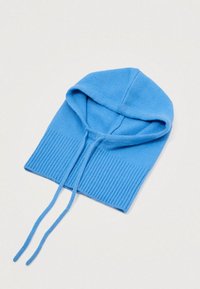 Capuz azul tricotado com textura em canelado na parte inferior, apresentando dois cordões longos para ajuste. Tecido macio e design finalizado.