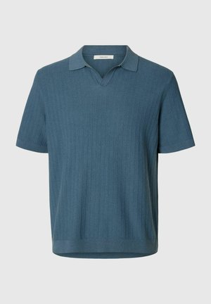 Tricou polo albastru cu mâneci scurte, tricotat, cu model texturat vertical în zig-zag și guler deschis pe un fundal gri deschis.