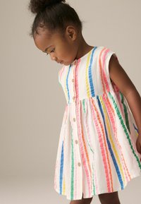 Robe rayée à manches courtes comportant des lignes verticales en rose, bleu, vert et jaune sur un fond blanc ; boutons en bois sur le devant.