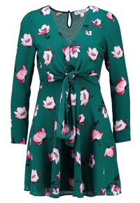 Zelené květinové šaty s dlouhými rukávy, véčkovým výstřihem, uzlovým detailem v pase a rozšířenou sukní. Obsahují růžové a bílé květinové vzory po celém povrchu.