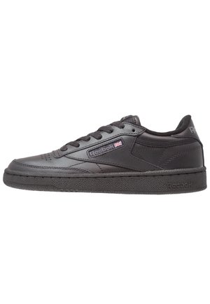 Sort Reebok lav-top sneaker med snørelukning, tekstureret sål og lille britisk flaglogo på sidepanelet.