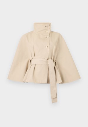 Manteau court style cape beige avec col montant, boutons sur le devant, manches larges et ceinture assortie nouée à la taille.