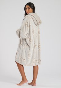 Bata de felpa con capucha en gris claro con patrón de osito de peluche. Presenta mangas largas, textura suave y un ajuste relajado y oversize.