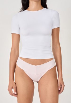 Top bianco a maniche corte e slip rosa. Il top è aderente con scollatura rotonda; gli slip hanno una vita a forma di V e design senza cuciture.