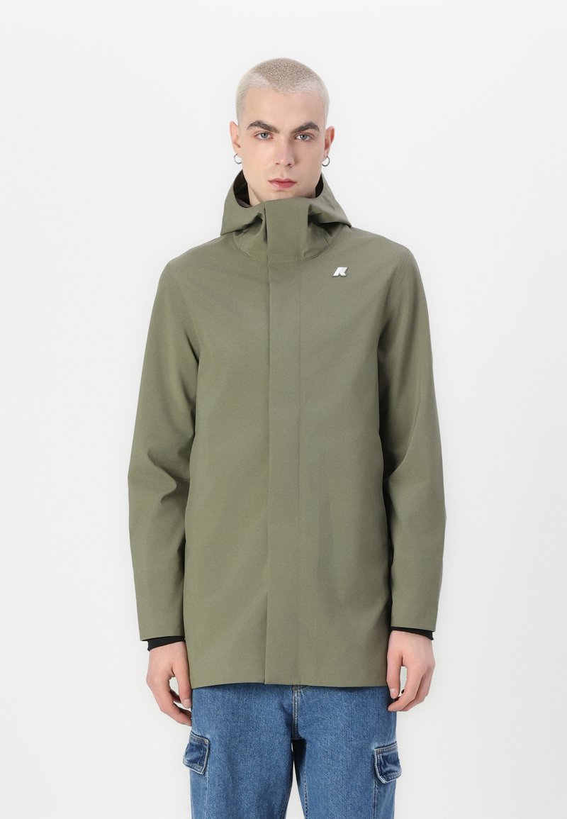 Jachetă impermeabilă de culoare verde măsliniu, cu guler înalt, design minimalist și un mic logo pe piept. Material texturat, închidere cu fermoar.