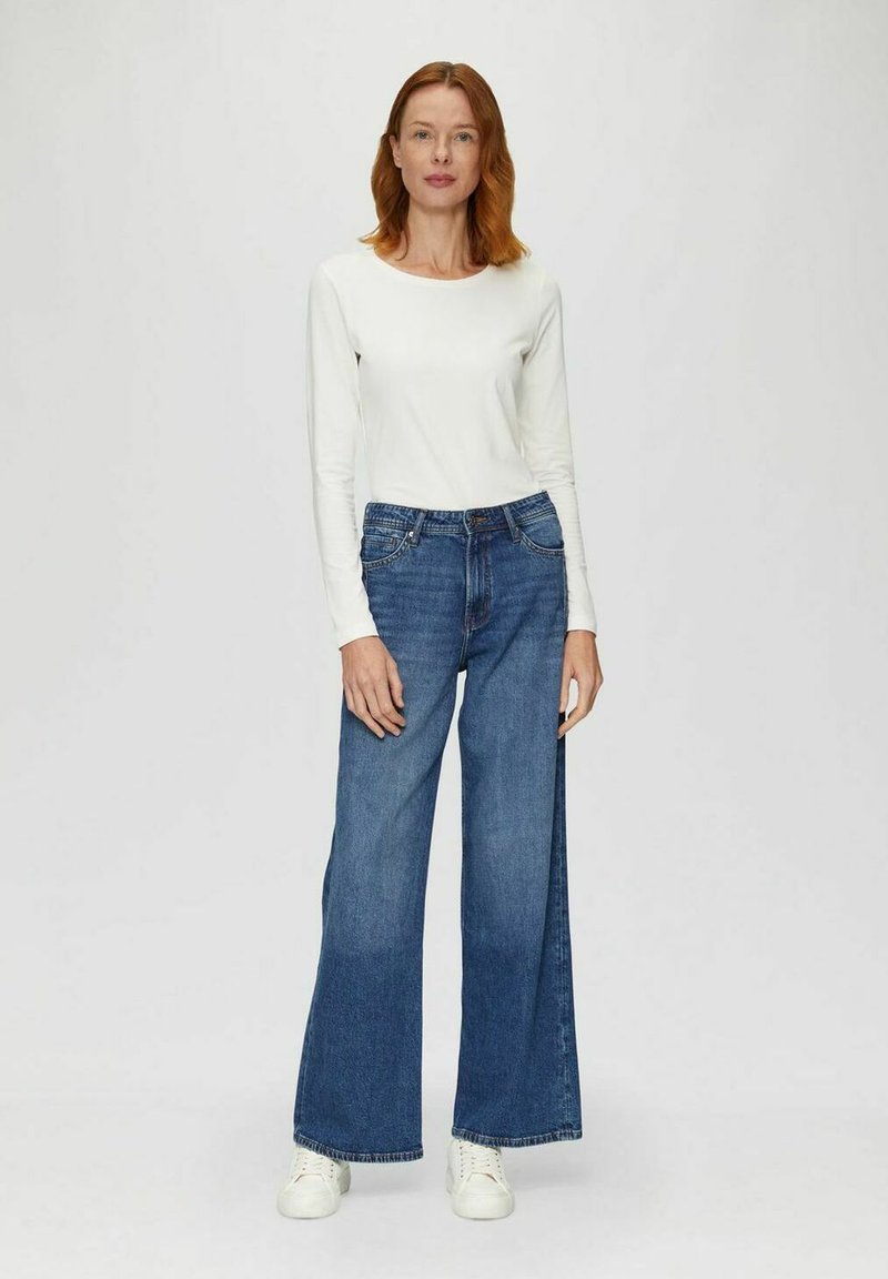 Wide-leg blue denim jeans with a high waist, featuring five pockets and classic stitching, paired with a long-sleeve white top.