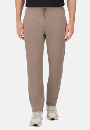 Lichtbruine joggingsbroek van een zachte jersey stof. Voorzien van een elastische tailleband met een trekkoord, zijzakken en een tapered leg design.