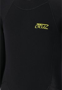Svart våtdräkt i slätt, stretchigt material. Har en gul "CRUZ"-logotyp och platta sömmar för hållbarhet. Utformad för vattenaktiviteter.