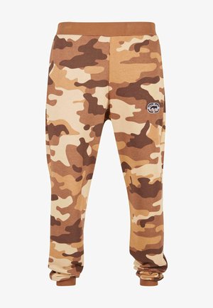 Camo joggingbroek in bruine en beige tinten, gemaakt van zachte stof, met een elastische tailleband en een klein logo-embleem op de zijkant.