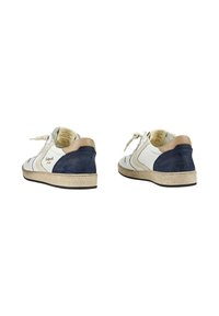 Sneakers bianchi in pelle con dettagli in suede blu navy e tallone beige. Presentano una suola texturizzata e lacci piatti. Design minimalista con branding sottile.